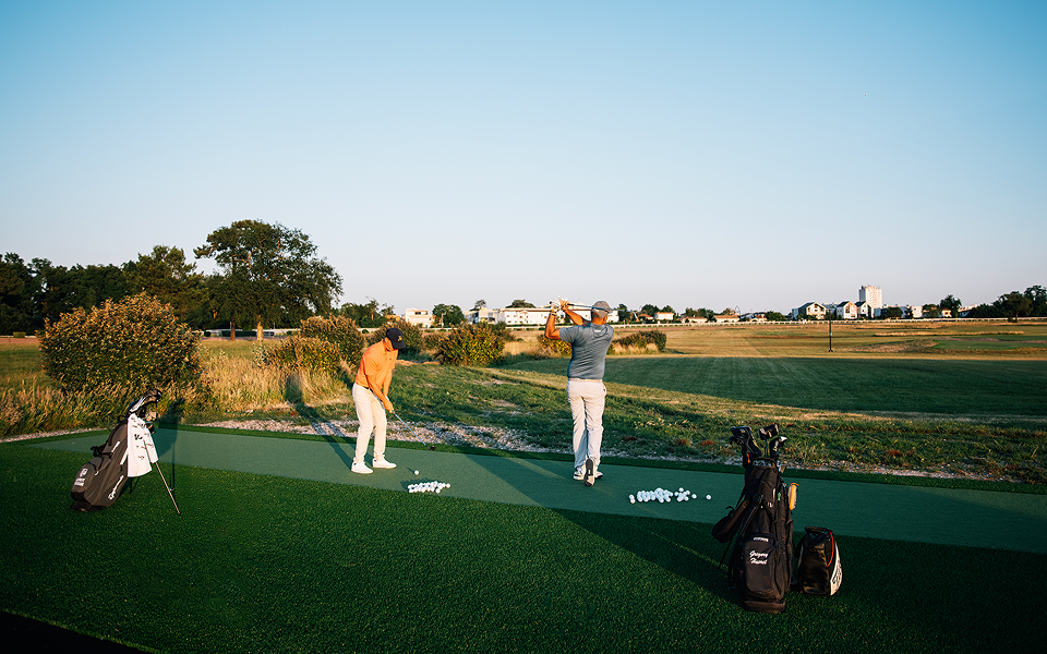 Deux hommes font du golf, ils tirent des balles.