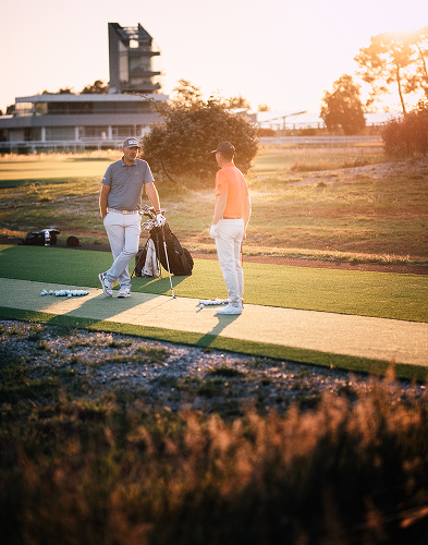 Deux hommes discutent sur un terrain de golf.
